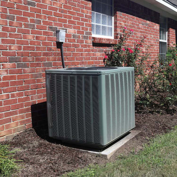 Residential heat pump outdoor unit installed beside a home Residential heat pump outdoor unit installed beside a home