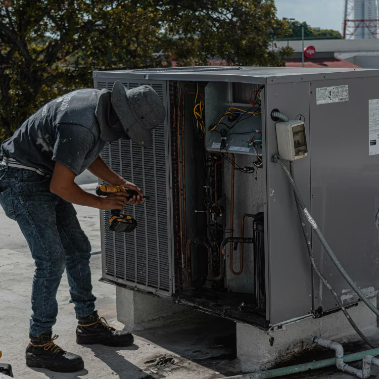 Technician servicing a commercial rooftop HVAC unit Technician servicing a commercial rooftop HVAC unit